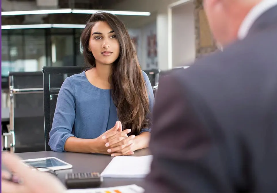 A woman sitting at a table with another man.