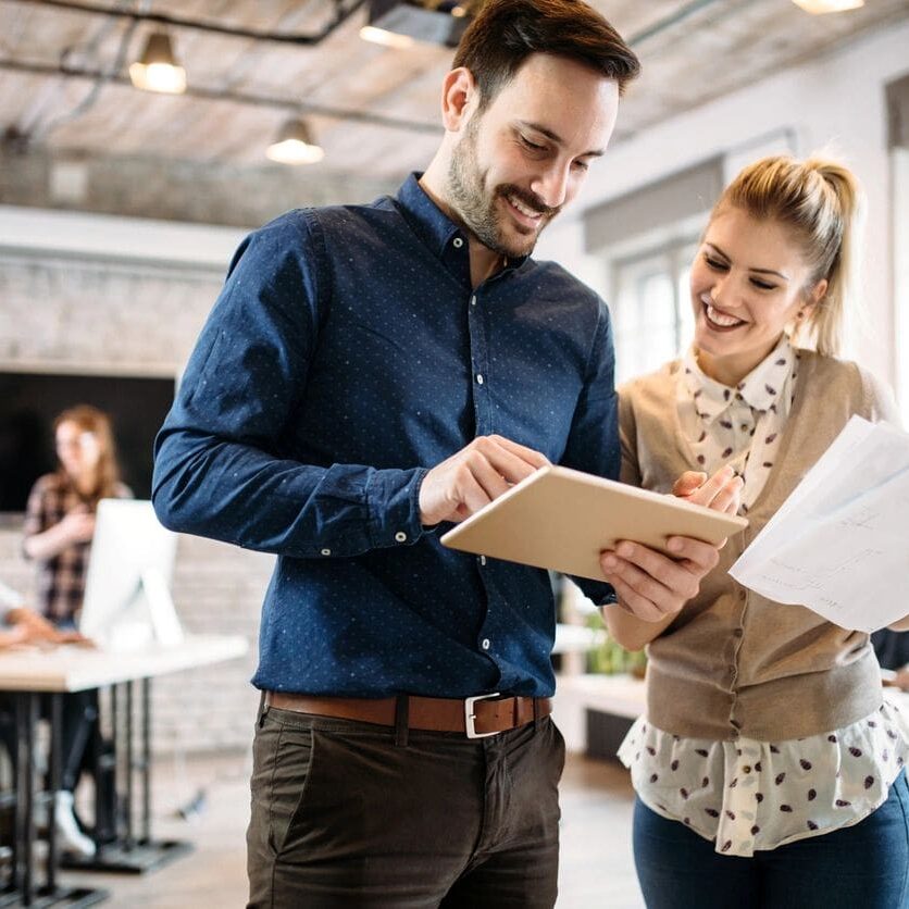 A man and woman looking at papers in an office.